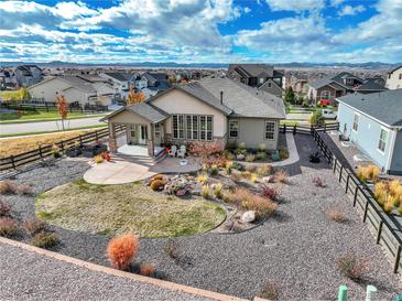 Landscaped backyard with gravel, grass and patio of a well-maintained single-Gathering home on a sunny day at 11950 Mosey Ct, Parker, CO 80138