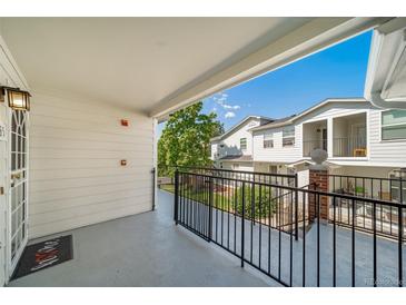 Spacious balcony featuring black metal railings and partial views of neighboring buildings and lush greenery at 1697 S Cole St # B5, Lakewood, CO 80228