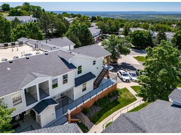 Exterior view featuring private balconies, manicured lawn, and parking at 1697 S Cole St # B5, Lakewood, CO 80228