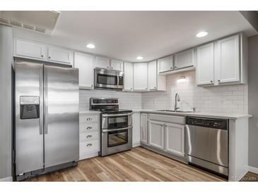 Modern kitchen with stainless steel appliances, white cabinetry, and stylish backsplash at 1697 S Cole St # B5, Lakewood, CO 80228