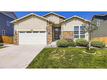 Charming home with a well-manicured lawn and beautiful stone accents on the facade at 6863 E 132Nd Pl, Thornton, CO 80602
