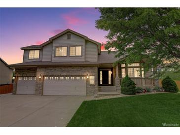 Charming two-story home with a well-manicured lawn and brick accents, enhanced by a lovely dusk sky at 14910 Williams St, Thornton, CO 80602