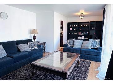 Comfortable living room featuring two sofas, a stylish coffee table, and hardwood floors at 413 Jamaica St, Aurora, CO 80010