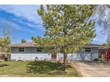 Charming single-story home featuring a landscaped front yard and a red front door under a bright blue sky at 576 S Tabor St, Elizabeth, CO 80107