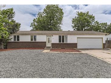 Charming single-story home featuring a brick facade, well-maintained lawn, and an attached garage at 16293 E Brown Pl, Aurora, CO 80013