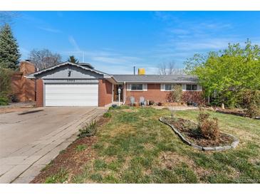 Charming single-story brick home with a well-maintained lawn, inviting curb appeal, and a two car garage at 3002 S Fenton St, Denver, CO 80227