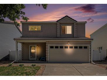 Charming two-story home with a well-maintained lawn and two-car garage against a beautiful evening sky at 4076 Andes Way, Denver, CO 80249