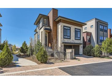 Modern two-story home featuring stone accents, wood siding, and a well-manicured front yard at 10119 Bellwether Ln, Lone Tree, CO 80124
