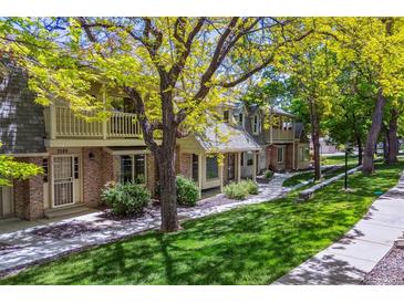 Charming townhouse featuring well-maintained landscaping, a walkway, and brick accents at 7589 S Cove Cir, Centennial, CO 80122