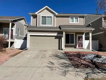 Tan two-story house with attached garage and landscaping at 18625 E 47Th Ave, Denver, CO 80249