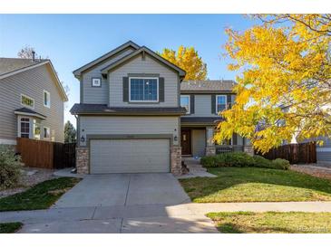 Two-story house with gray siding, attached garage, and landscaped yard at 3929 S Quemoy Ct, Aurora, CO 80018