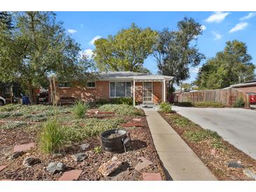 Brick ranch home with landscaped yard and a covered entryway at 3045 Xanadu St, Aurora, CO 80011