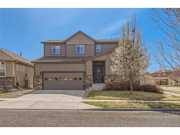 Charming two-story home featuring a two-car garage, stone accents, and a well-maintained front yard with flowering tree at 1421 Rustic Dr, Longmont, CO 80504