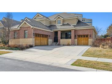 Charming two-story home features a brick exterior, tile roof, and attached two-car garage at 34 Sommerset Cir, Englewood, CO 80111