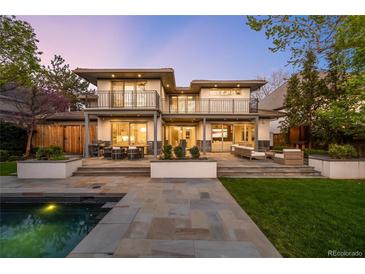 Stunning backyard featuring a pool, stone patio, seating, and a two-story home with balconies at 19 S Eudora St, Denver, CO 80246