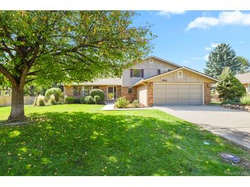 Charming two-story home featuring a well-manicured lawn, mature shade trees, and a two-car garage at 455 Greenwood, Longmont, CO 80504