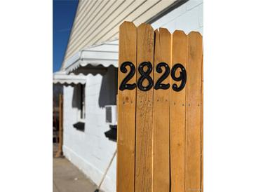Close-up of address on wooden fence, showcasing the property's street number in a clear, visible manner at 2829 W College Ave, Denver, CO 80219