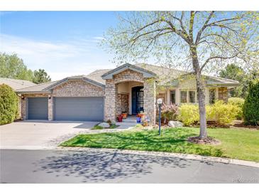 Charming single-story home features a stone facade, attached garage, and beautifully landscaped front yard at 12 Canon Cir, Greenwood Village, CO 80111