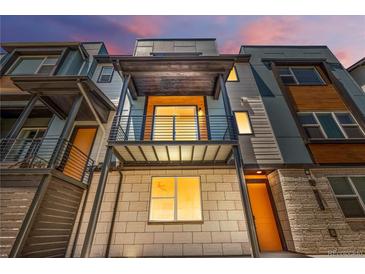 Modern three-story townhome with a metal balcony and a combination of siding and stone accents at 2347 Kite Route Ln, Superior, CO 80027