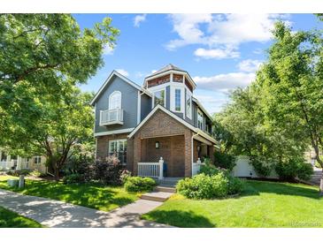 Charming two-story home featuring a turret, brick accents, balcony, and a well-manicured front yard at 7746 E Severn Pl, Denver, CO 80230