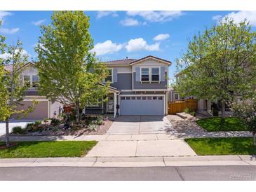 Charming two-story home with a well-manicured lawn, mature trees, and a two-car garage on a sunny day at 2320 Morningview Ln, Castle Rock, CO 80109
