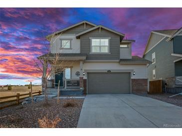 Charming two-story home with landscaped yard, two car garage and covered front porch with beautiful sunset at 610 Mosquito St, Elizabeth, CO 80107