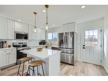 Modern kitchen with stainless steel appliances and white cabinetry at 9749 Steele St, Thornton, CO 80229