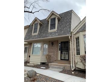 Charming townhouse featuring a decorative front door,dormer windows, and brick accents at 7565 S Cove Cir, Centennial, CO 80122