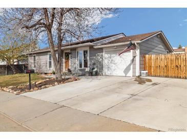 Charming gray single-story home with a well-maintained front yard, concrete driveway, and an attached garage at 1049 Lilac St, Broomfield, CO 80020
