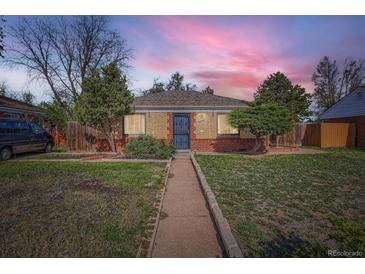 Charming brick home featuring a well-maintained lawn and walkway leading to the front door at 2220 Quebec St, Denver, CO 80207