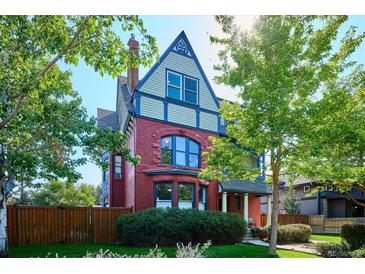 Brick home with a charming front porch and mature landscaping at 1800 S Sherman St, Denver, CO 80210