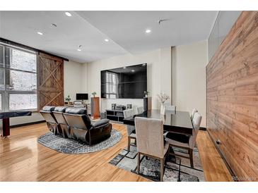 Modern living and dining area featuring hardwood floors and industrial chic accents and modern black leather reclining sofa at 720 16Th St # 421, Denver, CO 80202
