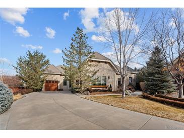 Attractive stone home with a long driveway and mature landscaping at 65 Royal Ann Dr, Englewood, CO 80111