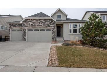 Charming home featuring a stone facade, attached two-car garage, and well-manicured front yard at 8791 Culebra Ct, Arvada, CO 80007