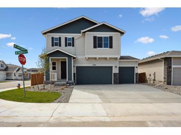 Charming two-story home showcasing a three-car garage and well-manicured landscaping with a spacious driveway at 45952 Gentry Ave, Bennett, CO 80102