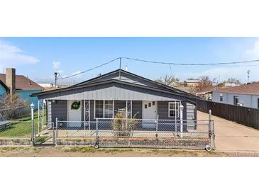 Charming gray home with a cozy, fenced front yard and inviting curb appeal at 13619 Lake Ave, Brighton, CO 80603