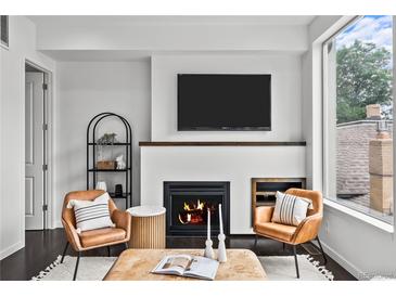 Cozy living room with a sleek fireplace, modern furniture, and abundant natural light from a large window at 3131 Vallejo St, Denver, CO 80211