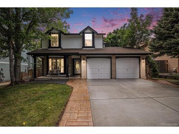Charming two-story home with a well-manicured lawn and attached two car garage at 11022 Trailrider Pass, Littleton, CO 80127