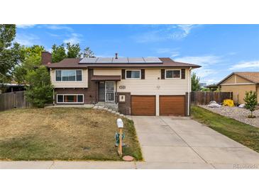Charming two-story home with an attached two-car garage and solar panels on the roof at 1261 Eagle St, Aurora, CO 80011