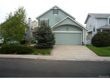 Charming home featuring light-green siding, an attached two-car garage, and a well-maintained front lawn at 21734 Farmingdale Ct, Parker, CO 80138