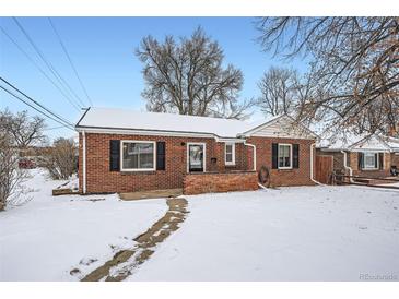 Brick ranch home with snow-covered yard at 7505 Robinson Way, Arvada, CO 80003