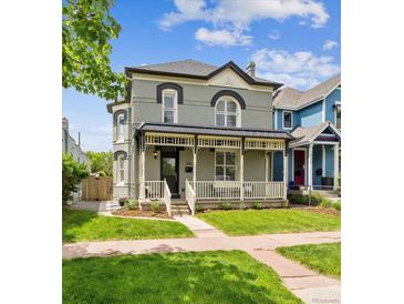 Charming two-story home features a covered front porch and a well-manicured lawn at 1016 31St St, Denver, CO 80205