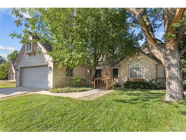 Charming single-Gathering home with well-manicured lawn, mature trees, and a welcoming entrance at 6073 W Adriatic Pl, Lakewood, CO 80227