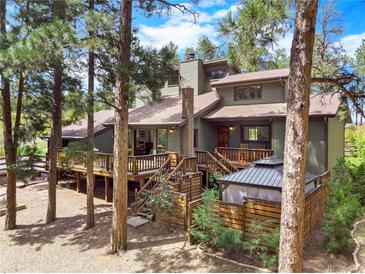 Charming multi-level home showcasing a wooden deck and gazebo surrounded by mature trees in a serene setting at 4515 Red Rock Dr, Larkspur, CO 80118
