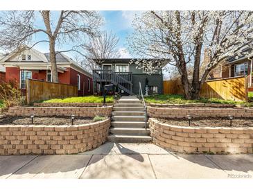 Charming home with a raised brick front yard, inviting entrance staircase, and well-maintained landscaping at 3233 Meade St, Denver, CO 80211
