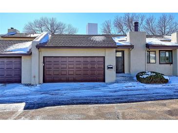 Exterior of charming townhome with brown garage door and snow-covered driveway at 1120 Cholla Ln, Broomfield, CO 80020