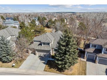 This is an aerial view of a lovely home in a treed neighborhood, with a large manicured yard and a welcoming driveway at 16302 Parkside Dr, Parker, CO 80134