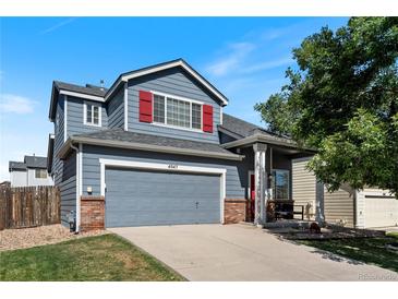 Charming two-story home with a gray exterior, red shutters, a well-manicured lawn, and an attached two-car garage at 4947 Stoneham Ave, Castle Rock, CO 80104