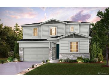 Charming two-story home featuring a two-car garage, stone accents, manicured lawn, and inviting landscaping at 14099 Bunny Hop Ln, Parker, CO 80134