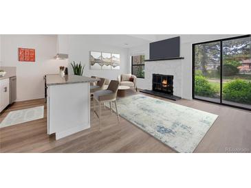 Stylish living area featuring a fireplace, TV, open to eat-in kitchen area and sliding glass doors at 225 E 8Th Ave # A2, Longmont, CO 80504